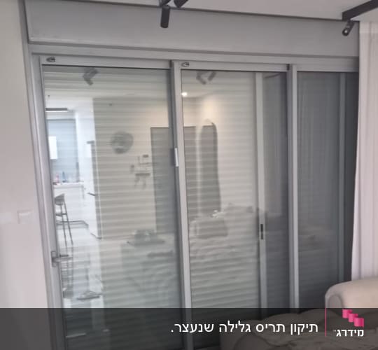 חלון הזזה מאלומיניום עם תריס גלילה ורשת בסלון דירה